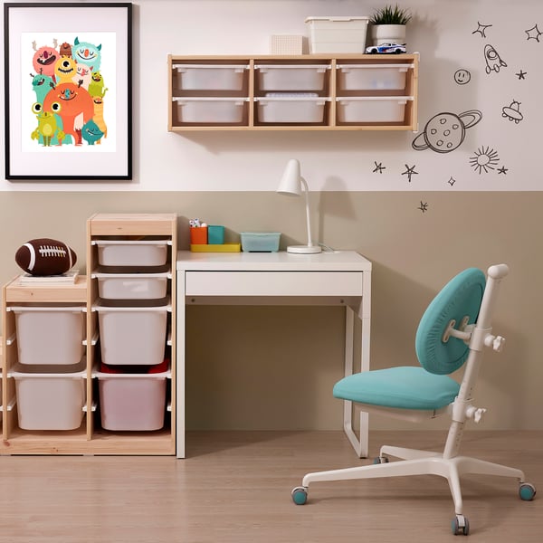 Kids study area with white MICKE desk, turquoise chair, wooden storage, and playful poster.