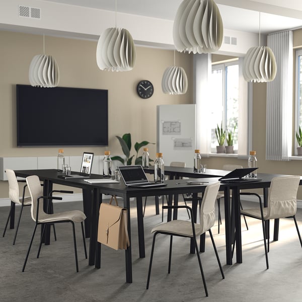 Modern office with MITTZON tables, chairs, lamps, screen, and clock - ideal for meetings.