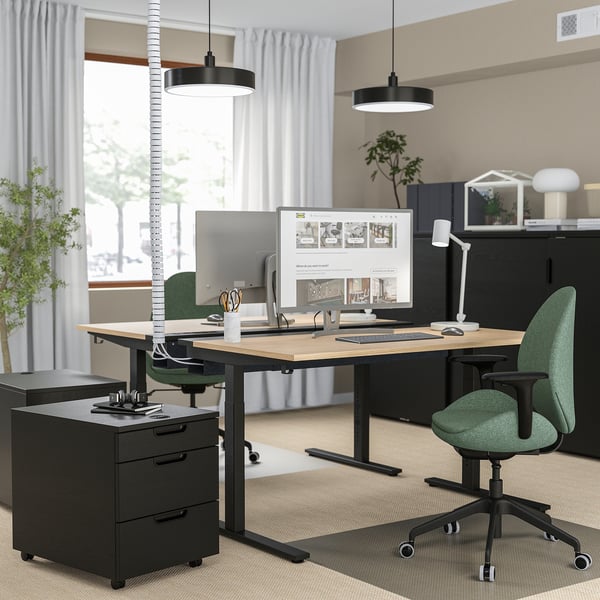 Modern workspace: MITTZON height-adjustable desk in black with green chair & monitor display, featuring sleek design and efficient organisation.
