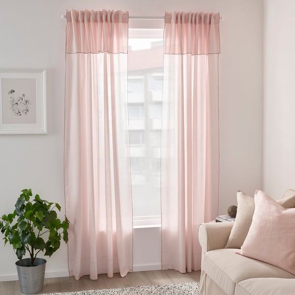 Bright room with large, light pink MOALISA curtains, pale plant, and cushioned chair.