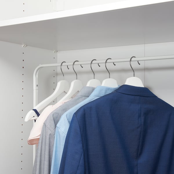 A white metal clothes rack holds several shirts on hangers. The rack multiple hooks and supports much more. Its compact size neatly organises clothes.