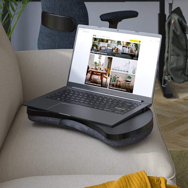 Laptop on black cushion stand, grey laptop open on couch.