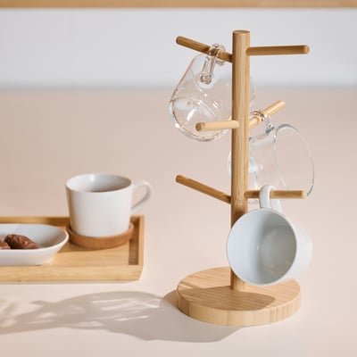 Bamboo mug tree with three mugs: one glass, one white, one blue. Includes a serving tray with small bowls.