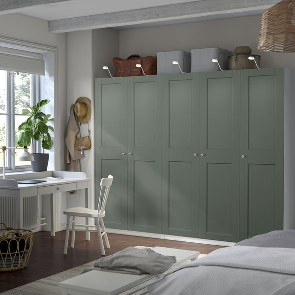 Green PAX wardrobe near white desk in organised room.