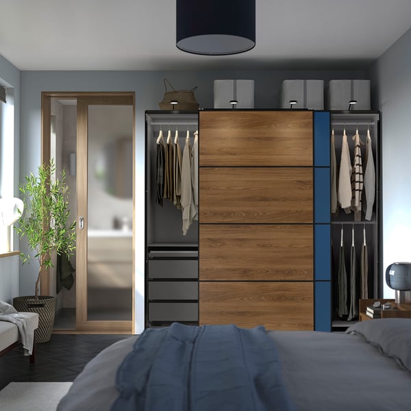 Modern bedroom with a PAX wardrobe featuring hanging clothes, drawers, and shelves.