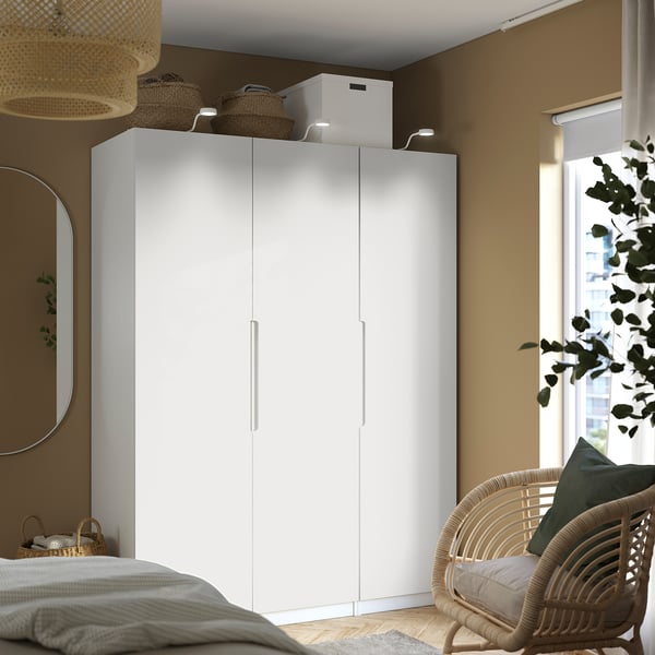 Spacious bedroom with tall white PAX wardrobe, mirror, and window.
