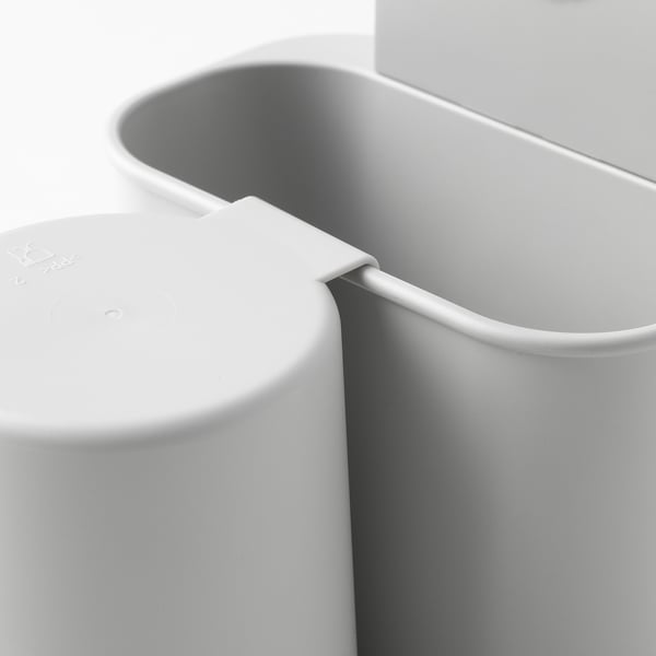 Modern dental storage with white toothbrush holder and attached cup, using suction to mount on smooth surfaces.
