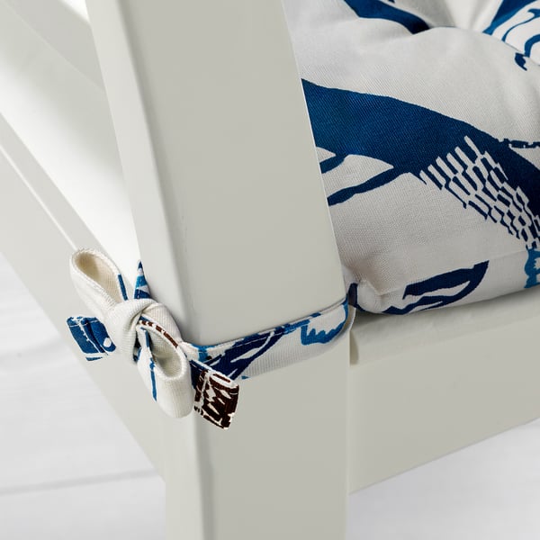 White chair cushions with blue patterns, tied with decorative bows.