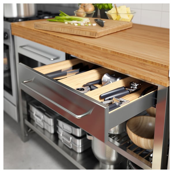 Kitchen drawer with bamboo top, stainless steel handle, and black utensils.