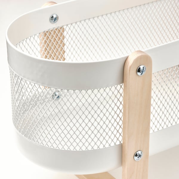 White metal mesh organiser with wooden legs. Rounded, sturdy design, three visible screws for assembly.