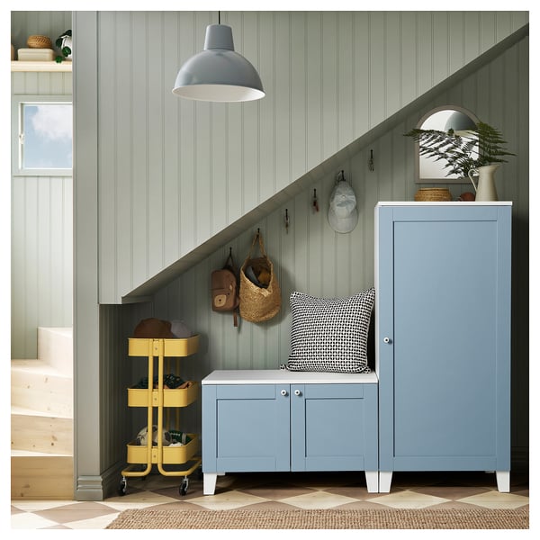 A SANNIDAL cabinet in light blue, featuring a classic design with two doors and a flat top, placed under a staircase.