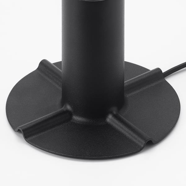Black table lamp with textured base and protective pads.