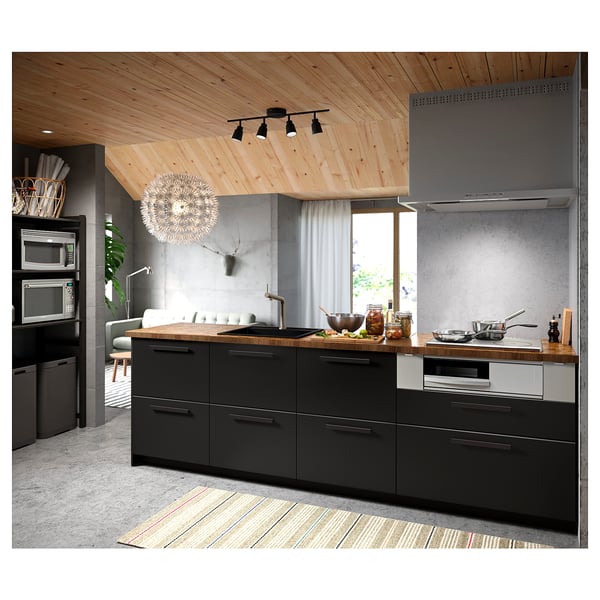 Modern kitchen with black cabinets, wooden countertop, stainless appliances, under-cabinet lighting, and a hanging sparkler light.