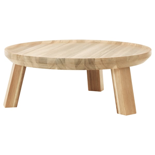 A round, light brown wooden SKOGSTA serving stand with four slanted legs, made of solid acacia.