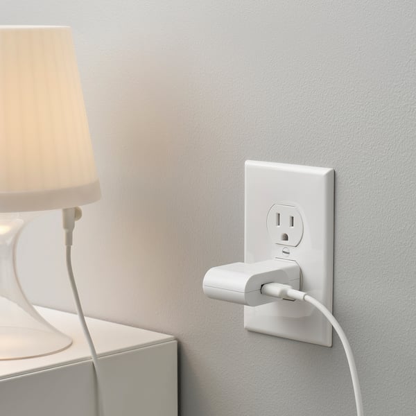 White wall socket with usb charger and lamp cord.