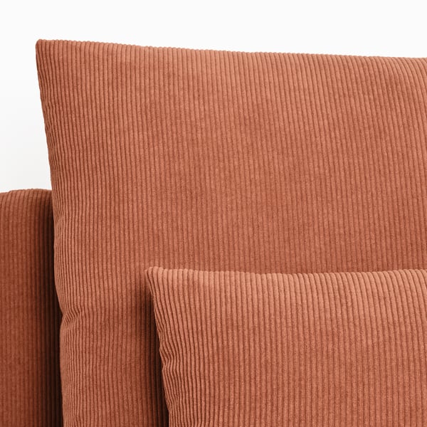 Close-up of rust-colored corduroy sofa, showcasing soft, ribbed texture and comfortable design.