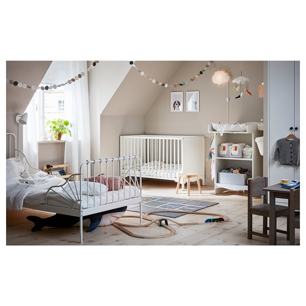 Childs bedroom with white SOLGUL crib, bed, and toy storage. Decorated with hanging lights, rug, and wooden toys.