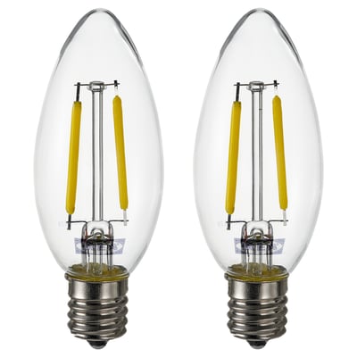 Two identical bulbs side by side. Clear glass with yellow led coils. E12 base. Rounded teardrop shape. No text.