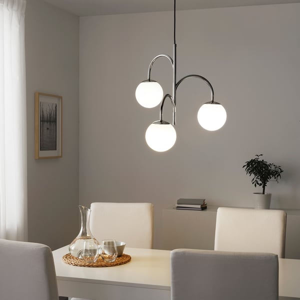 Modern dining area with hanging lights and styled decor, wall art.