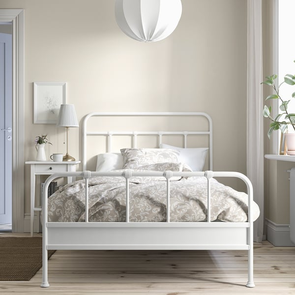 STJÄRNÖ metal bed with curved headboard in minimalist bedroom.