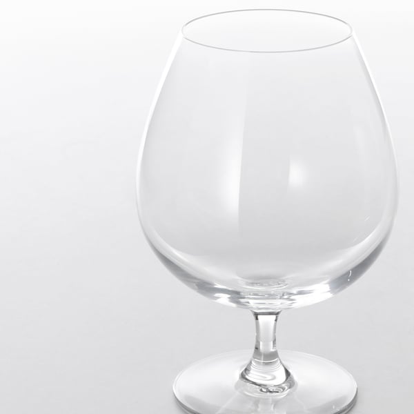 Elegant, clear crystal glass with smooth stem, reflecting light, standing on polished surface.