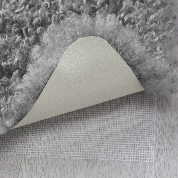 Fluffy, textured rug close-up, showing soft fibres, solid backing, and durable mesh base.
