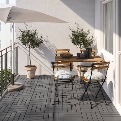 Small outdoor dining set with acacia wood table and black metal chairs. Perfect for balconies, foldable design.