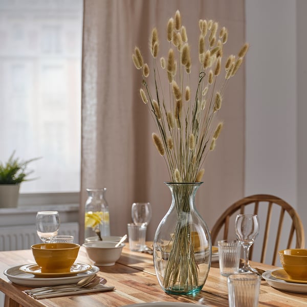 Table with wooden chairs and TORKA vase, dishes, glasses, & silverware.
