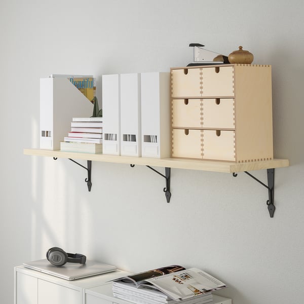 Wooden wall shelf with drawers and brackets holding white boxes and stacked books.