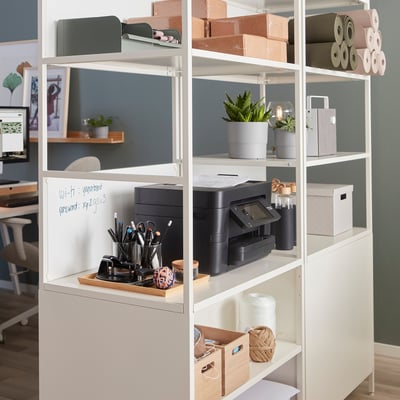 TROTTEN storage cabinet with printer, plants, and paper rolls, doubles as room divider, wi-fi password on door.