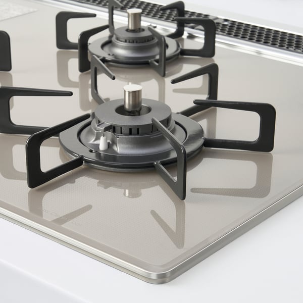 Stainless steel gas stove with four burners and black metal supports. High-quality, modern design.