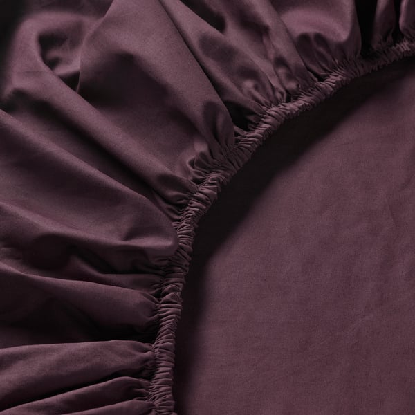 Close-up of burgundy fitted sheet with elastic edging, showcasing smooth, crisp texture and tight weave, highlighting its durable and soft quality.