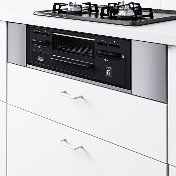 Built-in oven with sleek control panel and digital display, set within white cabinetry and black handles.