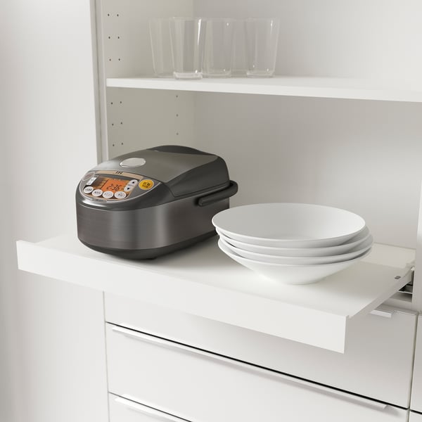 Pull-out shelf with small appliance and plates, maximising kitchen storage.