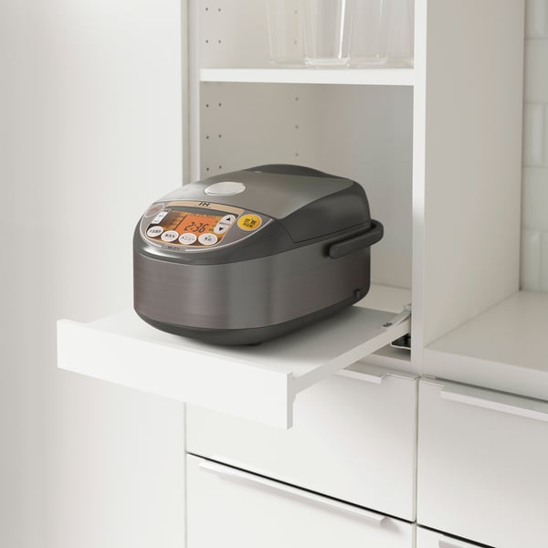 A kitchen shelf with a built-in pull-out tray holding a multi-functional rice cooker, enhancing accessibility and space utilisation.