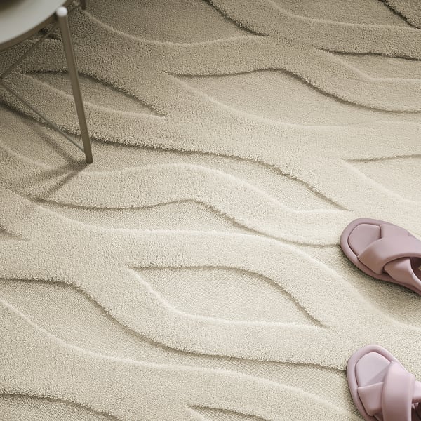 A plush rug with a wavy pattern and a pair of pink slippers near a metal chair leg on it.