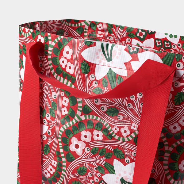 Red reusable shopping bag with festive floral pattern. Sturdy, recycled materials, handles for easy carrying.