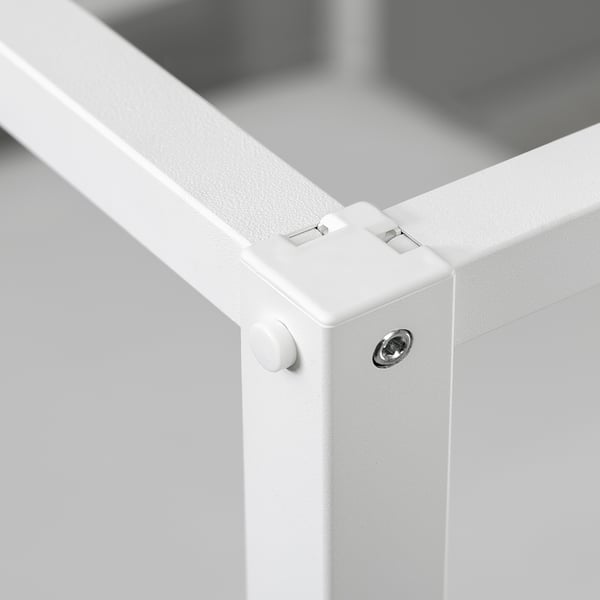 Close-up of VITARNA bed frame joint: sturdy white metal corners and screws.
