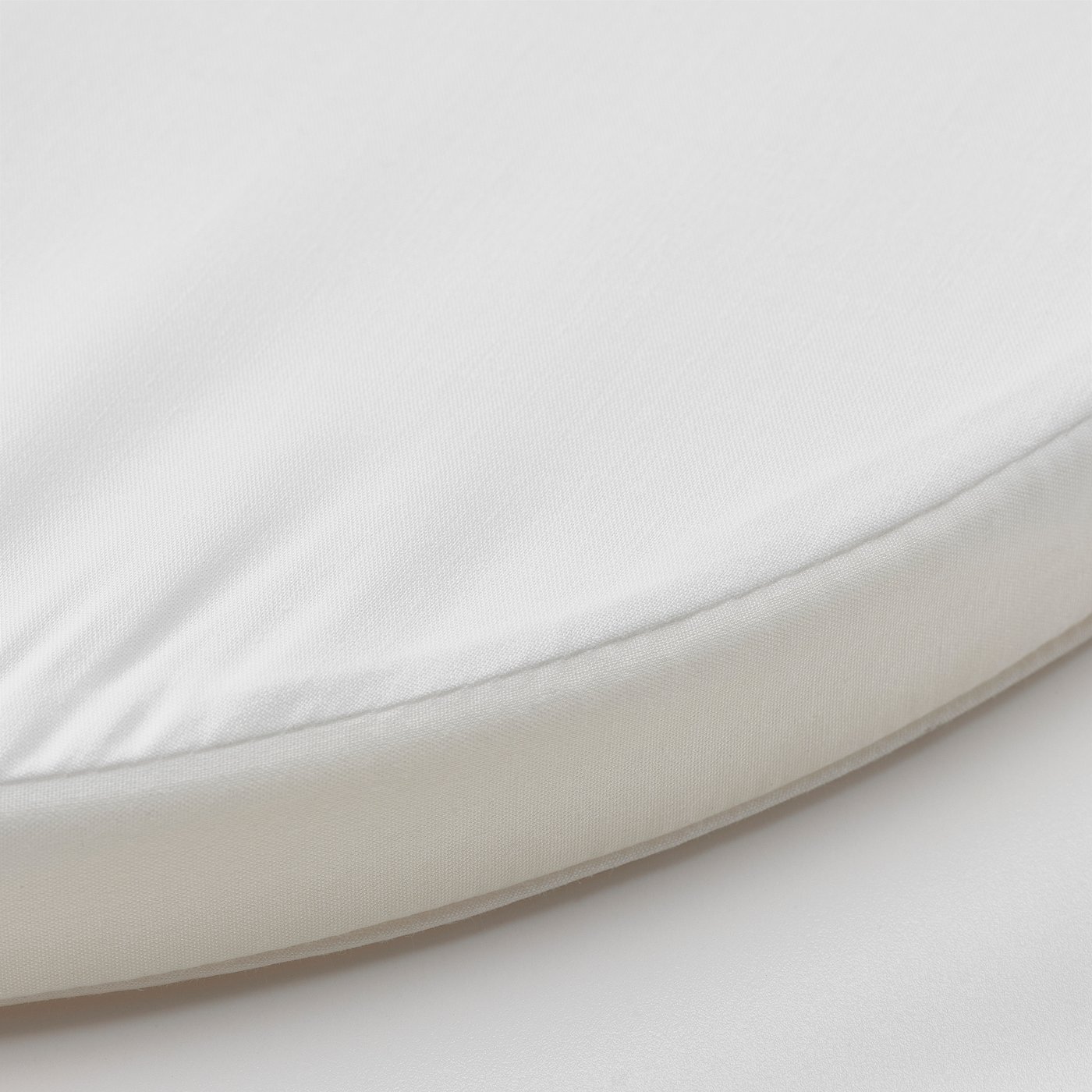 Circular, white baby mattress with smooth, adjustable fabric and simple design.