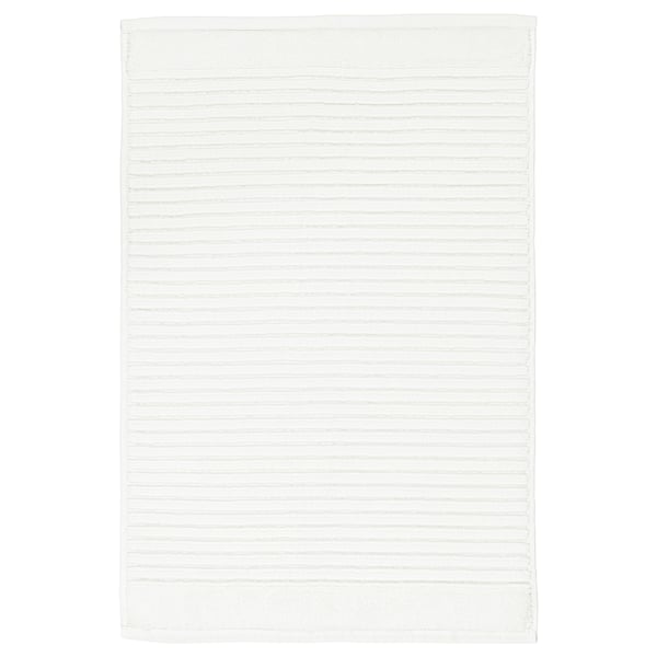 A white, rectangular ALSTERN cotton terry bath mat. Its design a textured surface for foot massage and quick drying.
