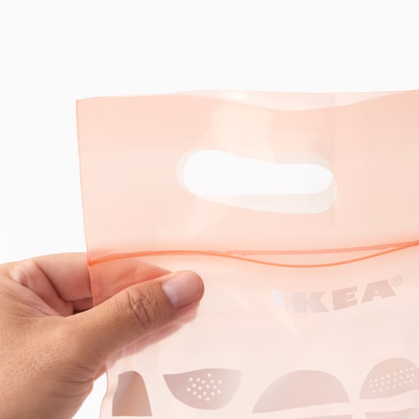 Person holding a clear pink ikea BEKOSTA bag, showing its resealable handle.