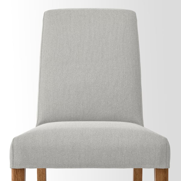 Upholstered chair w/ light grey fabric, high back, wooden legs, comfortable & durable.