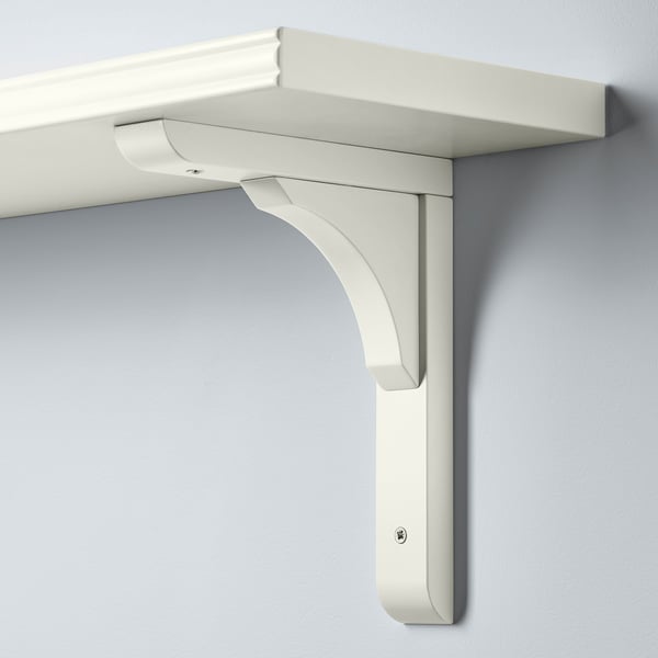 Wall-mounted shelf with smooth and bevelled edges, supported by a curved bracket. White colour, clean design.