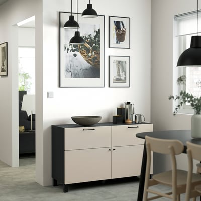 A modern white & black BESTÅ sideboard with drawers & shelves. Hangs art above. Large enough to hold dishes & decor near dining chairs.