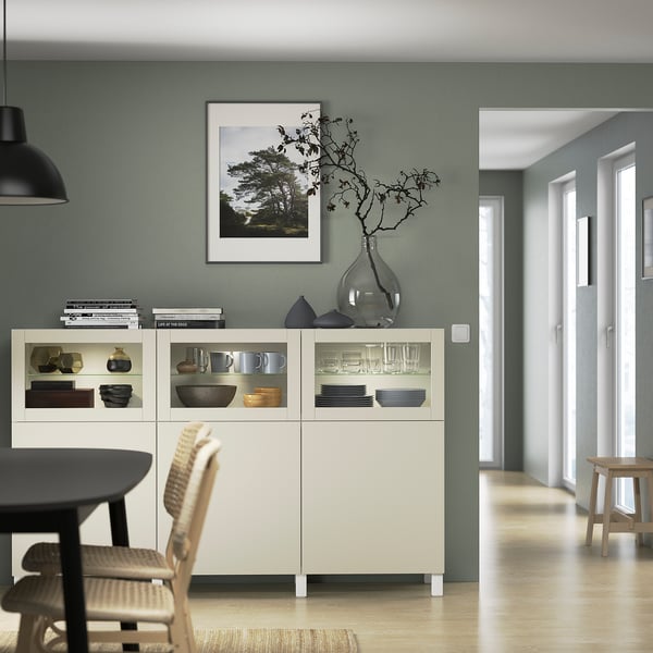 Modern dining area with BESTÅ sideboard, nature print, and wicker chairs.