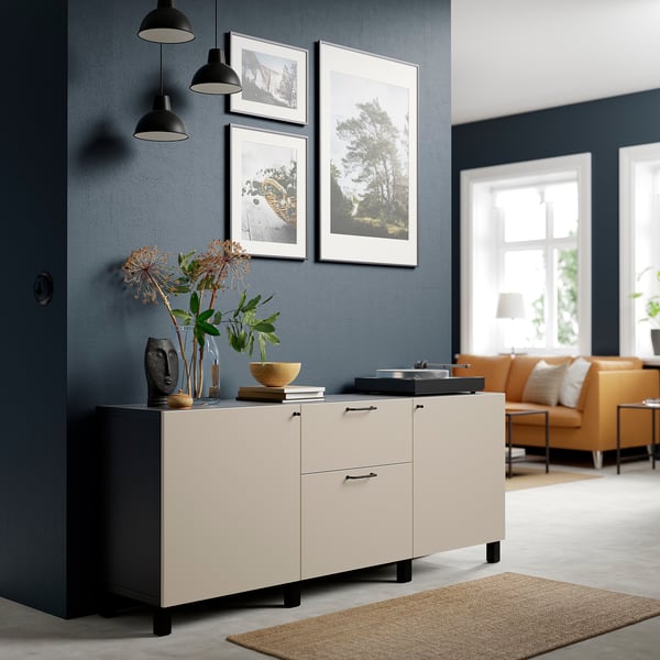 Beige BESTÅ sideboard with drawers, decorative items, pendant lamps, and photos in modern living space.