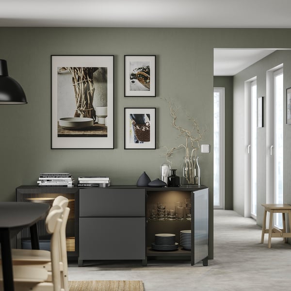 Modern living room with BESTÅ storage unit, green walls, and decor.