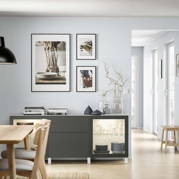 Modern dining area with light wood table, grey sideboard, and framed photos.