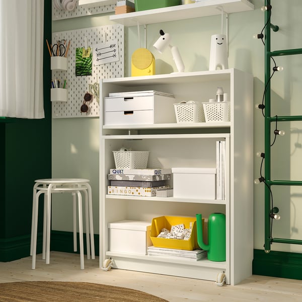 Organised shelf unit with storage boxes, books, and games; includes foldable table for workspace.