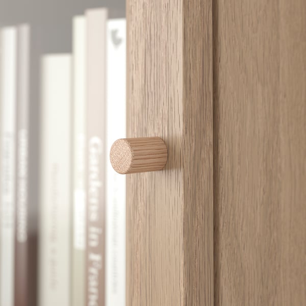 Close-up of modern wooden knobs on a bookcase, showcasing textured, natural finish.
